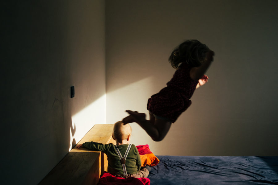 Young Child Jumping On Bed